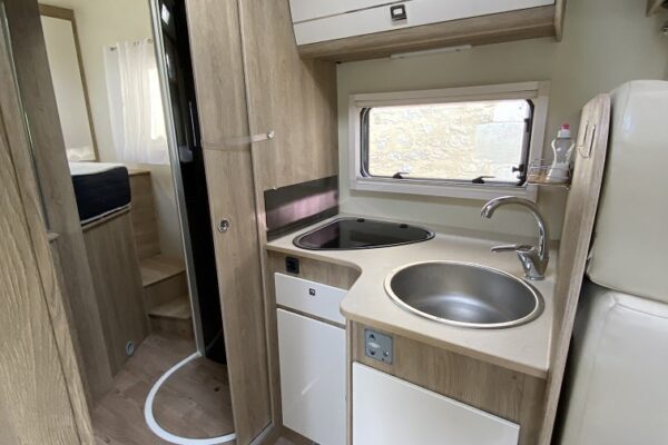 Intérieur moderne de camping-car avec cuisine équipée.