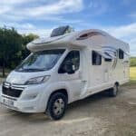 Camping-car blanc stationné en pleine nature.