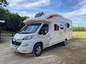 Camping-car blanc stationné en pleine nature.