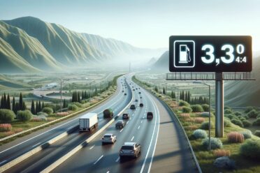 Autoroute, panneau essence, prix, paysage montagneux, véhicules.