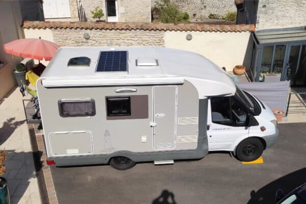 Camping-car blanc équipé de panneau solaire.