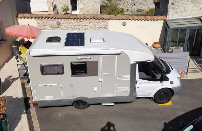 Camping-car blanc équipé de panneau solaire.