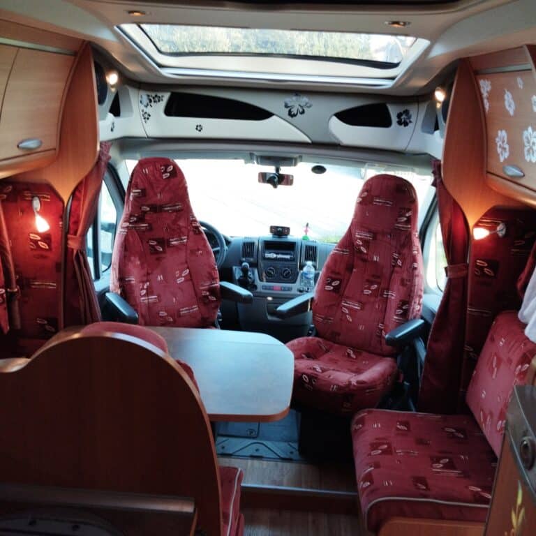 Intérieur confortable de camping-car avec sièges rouges.