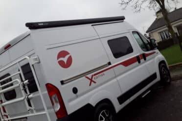 Fourgon blanc stationné, jour pluvieux.