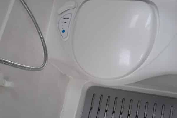 Douche moderne avec siège intégré et commande ajustable.