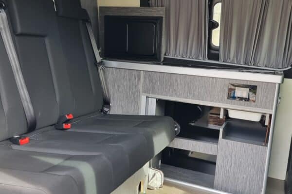 Intérieur moderne de camping-car avec sièges et cuisine.