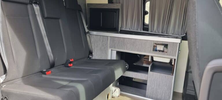 Intérieur moderne de camping-car avec sièges et cuisine.