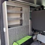 Intérieur de véhicule aménagé avec armoire et rangements.