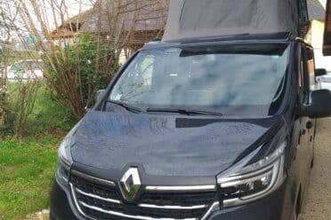 Fourgon aménagé avec toit relevable stationné.