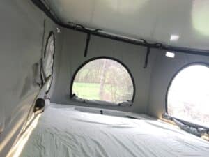 Intérieur de tente avec vue sur forêt.