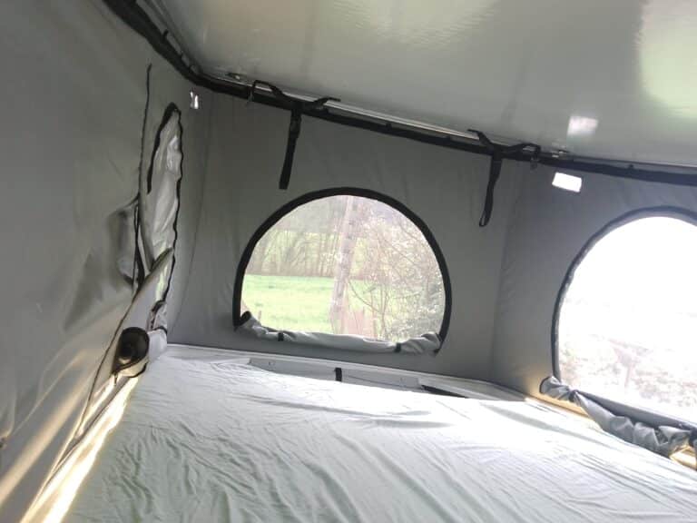 Intérieur de tente avec vue sur forêt.