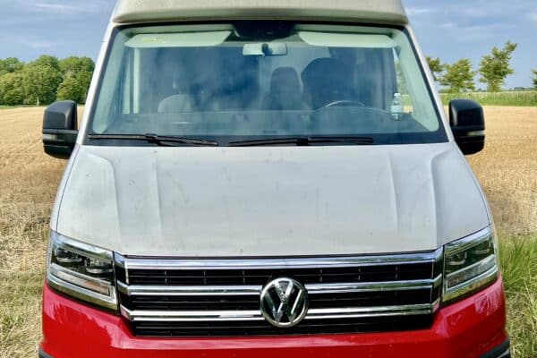 Kastenwagen Rot-weißer Volkswagen in einem Feld.