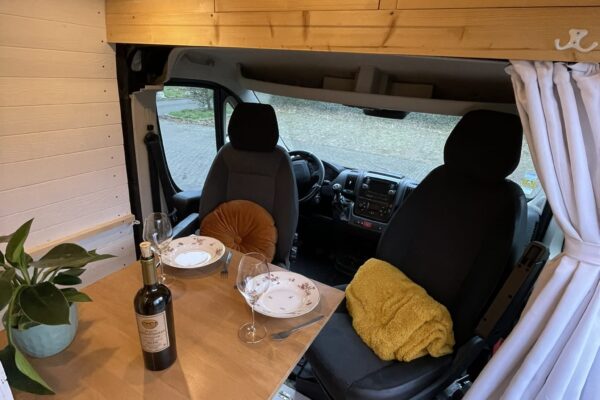 Gemütliche Inneneinrichtung von Campervan für das Abendessen.
