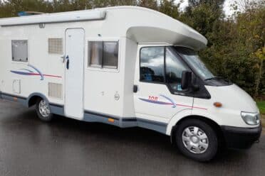 Camping-car blanc stationné en extérieur