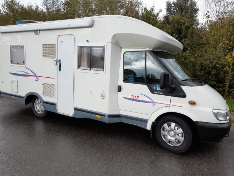 Camping-car blanc stationné en extérieur