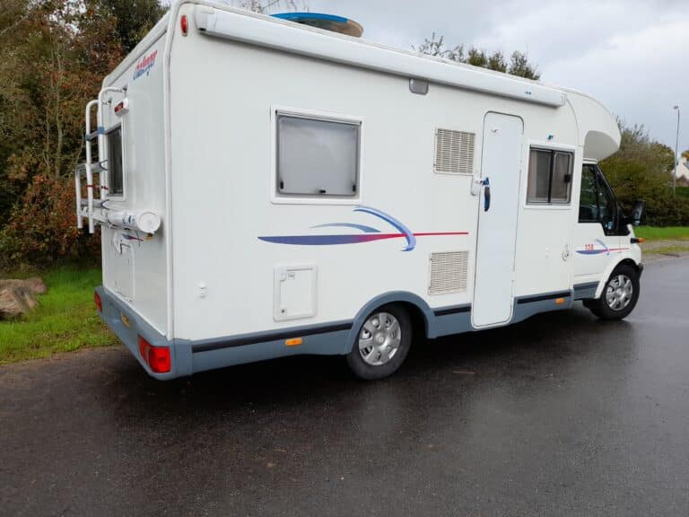 Camping-car blanc stationné en extérieur