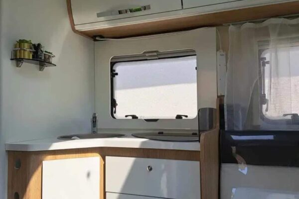 Moderne Inneneinrichtung von Wohnmobil mit Küche und Stauraum.