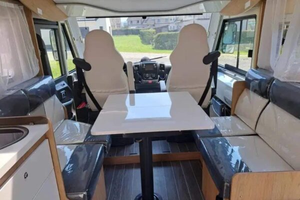 Moderne Inneneinrichtung von Wohnmobil mit Sitzen und Tisch.