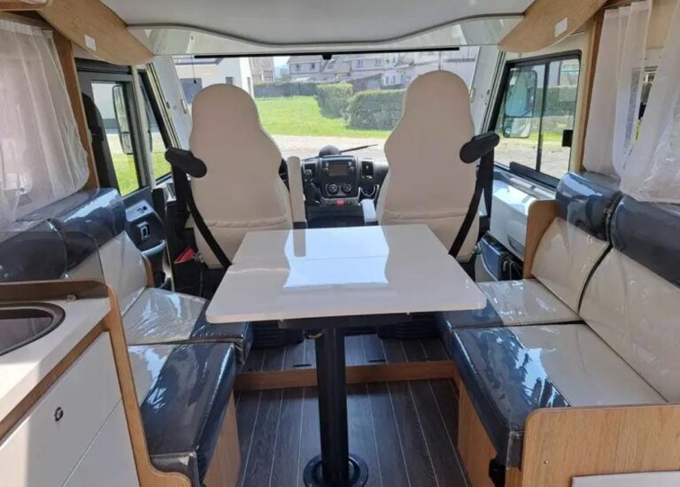 Intérieur moderne de camping-car avec sièges et table.