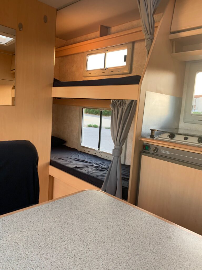 Intérieur de camping-car avec lits superposés et cuisine