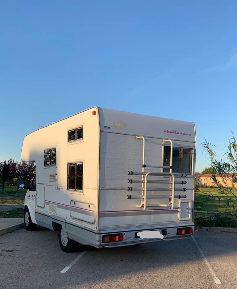 Camping-car stationné en extérieur au crépuscule.