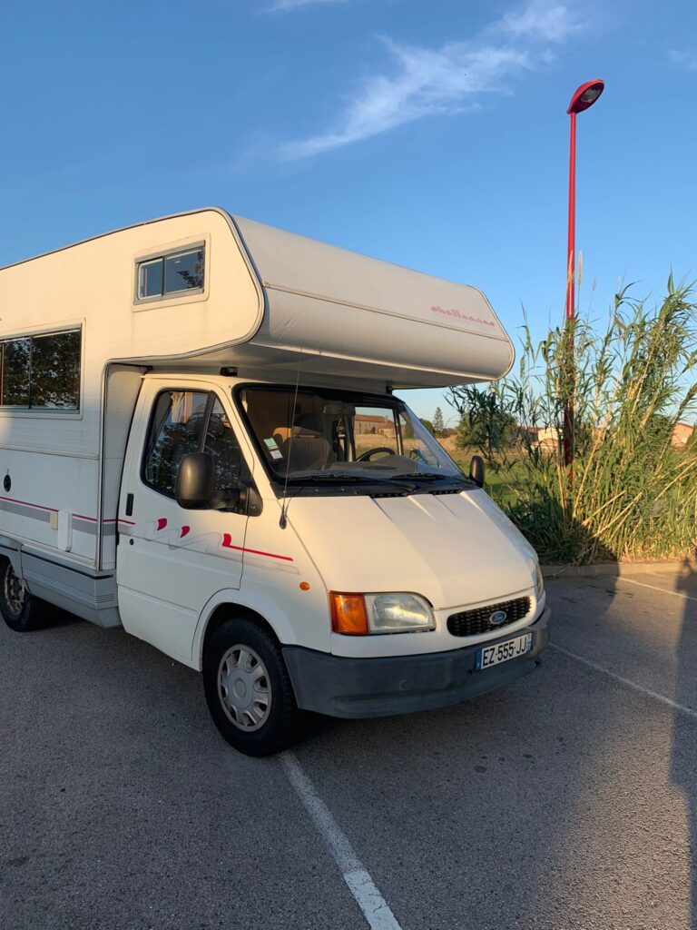 Camping-car blanc stationné au coucher du soleil