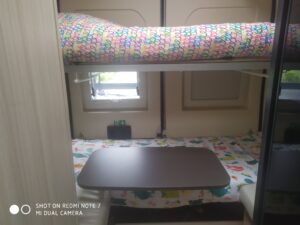 Intérieur de caravane avec lits superposés et table.