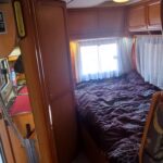Intérieur cosy de camping-car avec lit et cuisine.