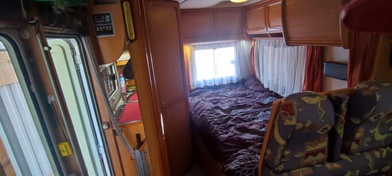 Intérieur cosy de camping-car avec lit et cuisine.