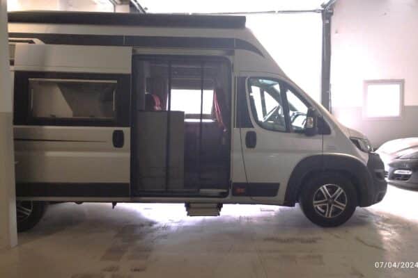 Wohnmobil weiß in einer beleuchteten Garage.