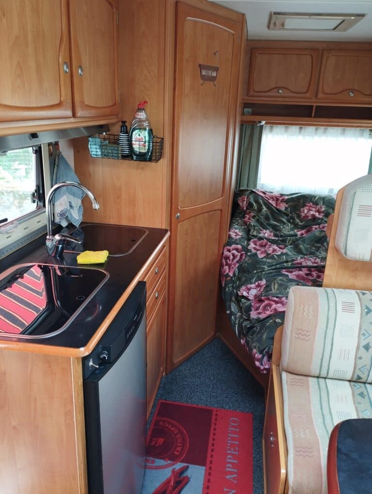 Intérieur confortable de camping-car avec cuisine et lit.