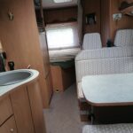 Intérieur confortable de camping-car avec lits et cuisine équipée.