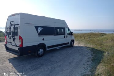 Fourgon aménagé sur plage côtier.