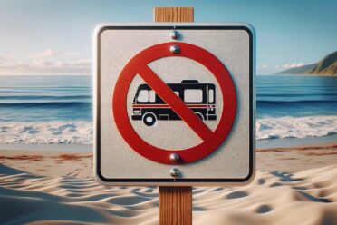 Panneau interdiction bus sur plage sableuse.