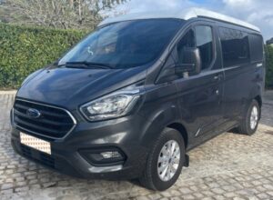 Fourgonnette noire Ford garée en extérieur.