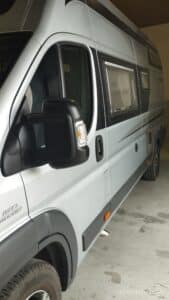 Camping-car moderne gris stationné en garage.