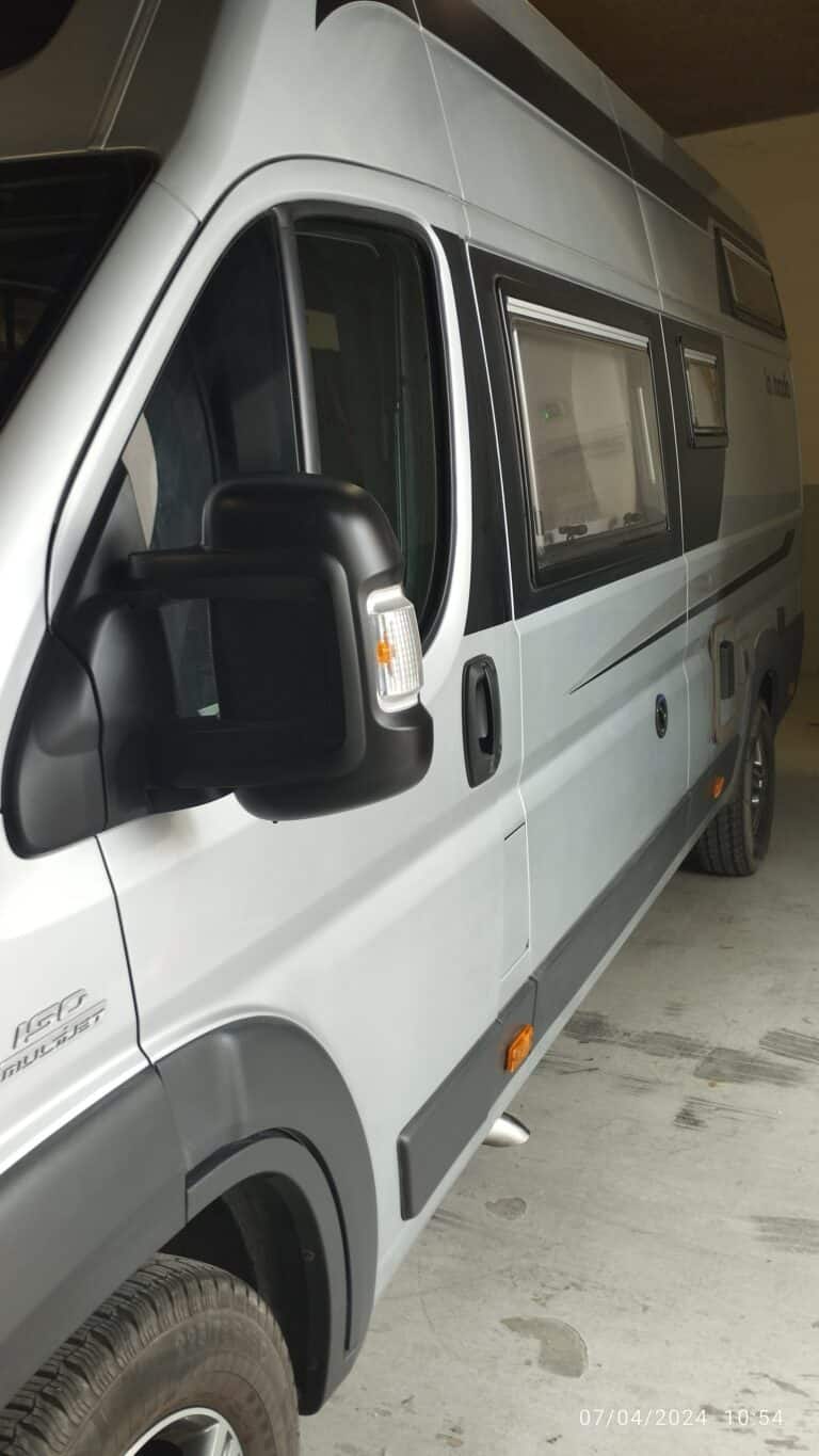Camping-car moderne gris stationné en garage.