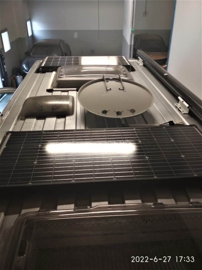 Panneaux solaires sur toiture de véhicule dans garage.