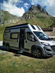 Camping-car moderne devant montagnes pittoresques.