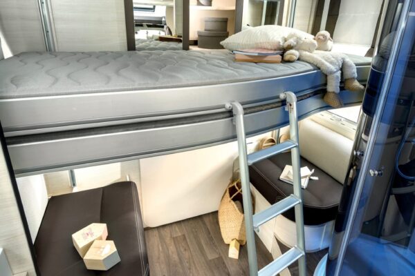 Intérieur moderne de camping-car avec lits superposés et cuisine.