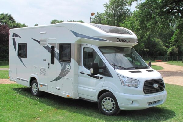 Camping-car Chausson blanc moderne garé dans un parc.