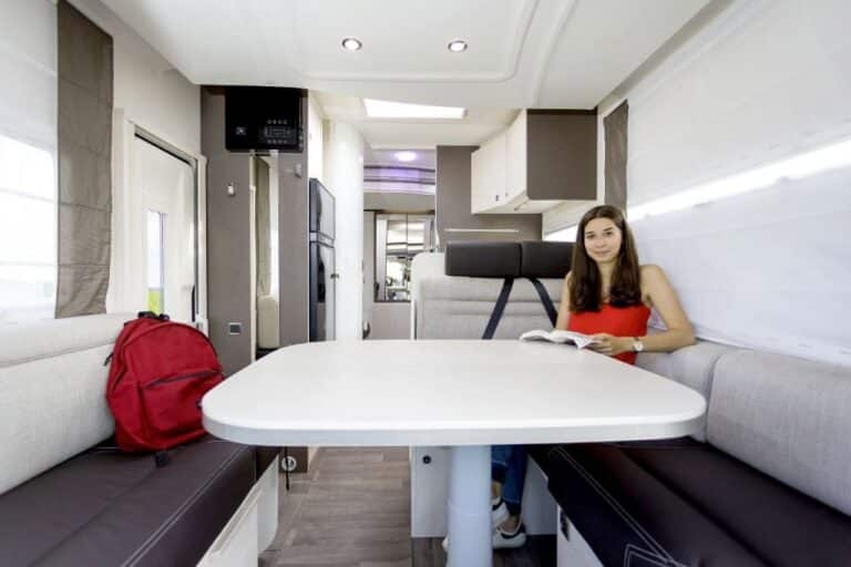 Jeune femme lisant dans un camping-car moderne.