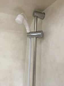 Douchette et support métallique dans salle de bains.