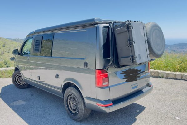 Kastenwagennette grau ausgestattet, sonnige Berglandschaft.