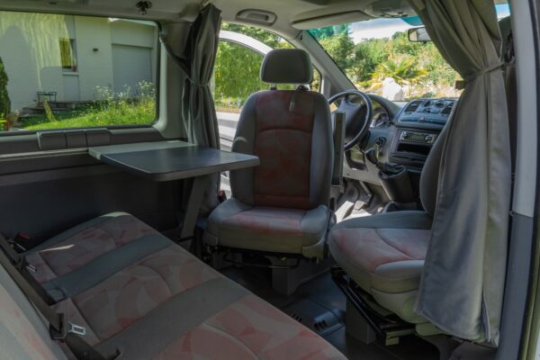 Inneneinrichtung von Campervan mit Sitzen und Tisch.