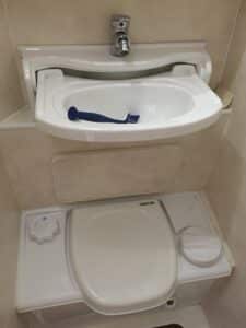Salle de bains avec lavabo et toilettes intégrés.