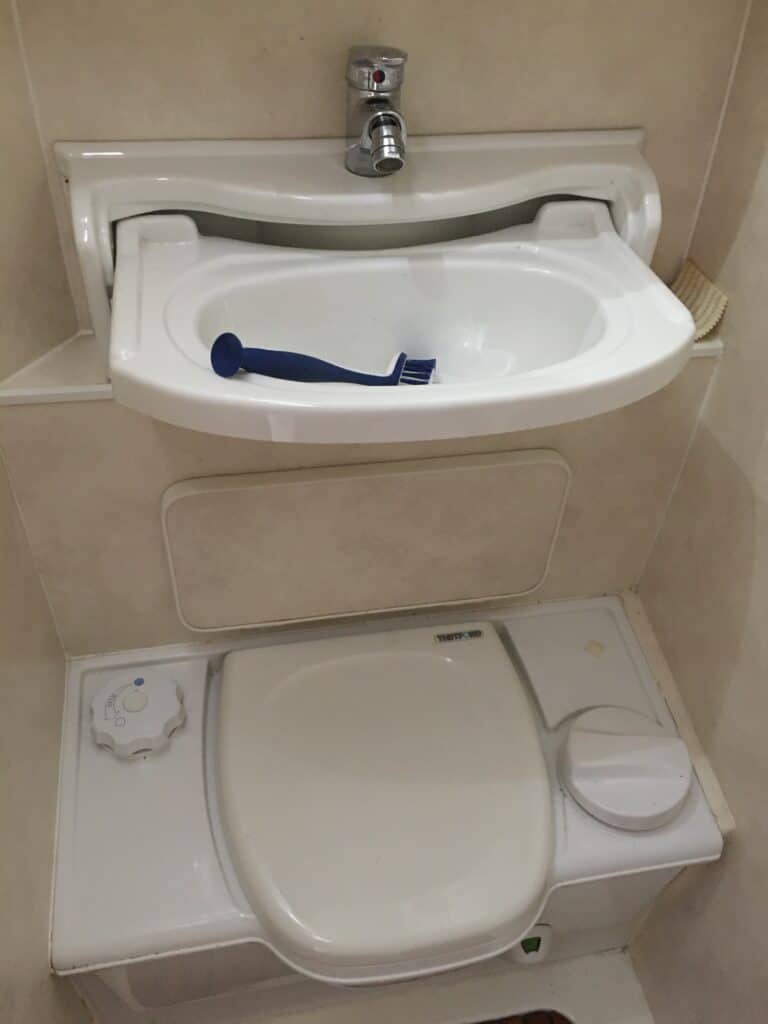 Salle de bains avec lavabo et toilettes intégrés.