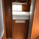 Intérieur de caravane avec lit confortable et rangements.