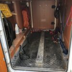 Intérieur d'une remorque avec outils et équipements suspendus.