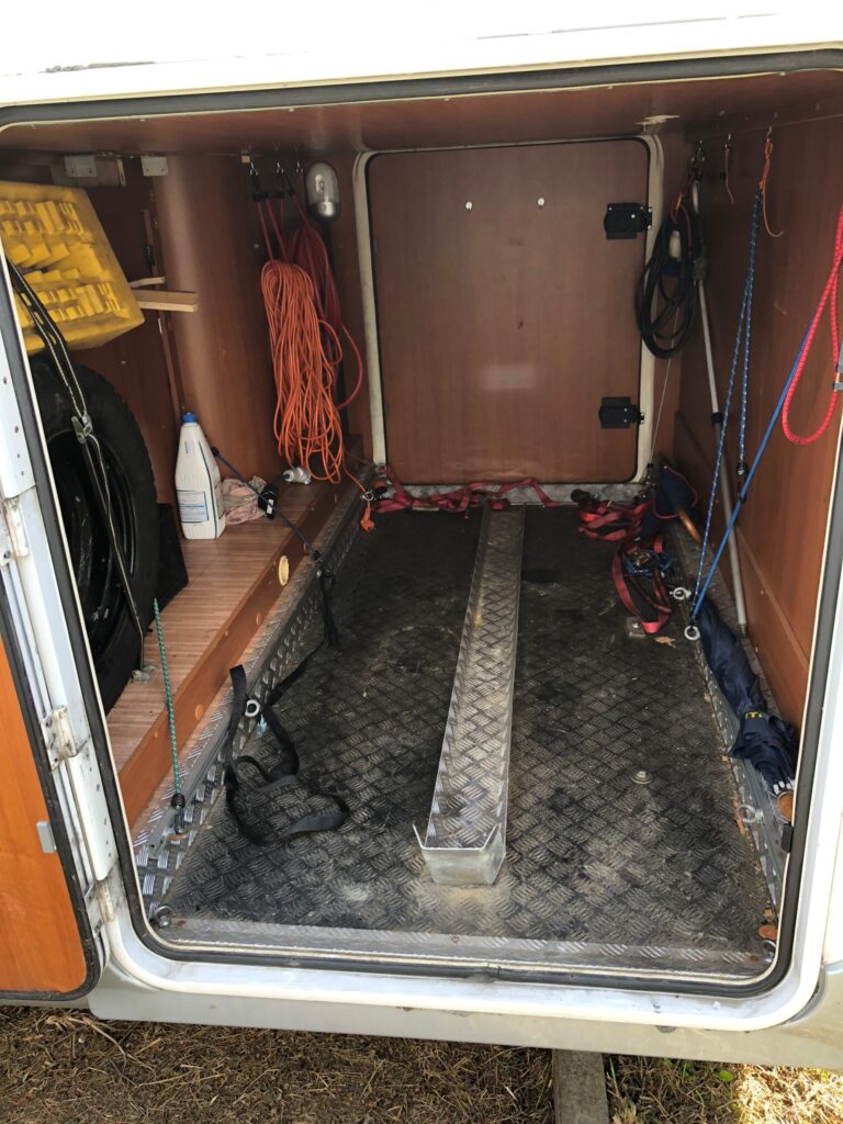 Intérieur d'une remorque avec outils et équipements suspendus.